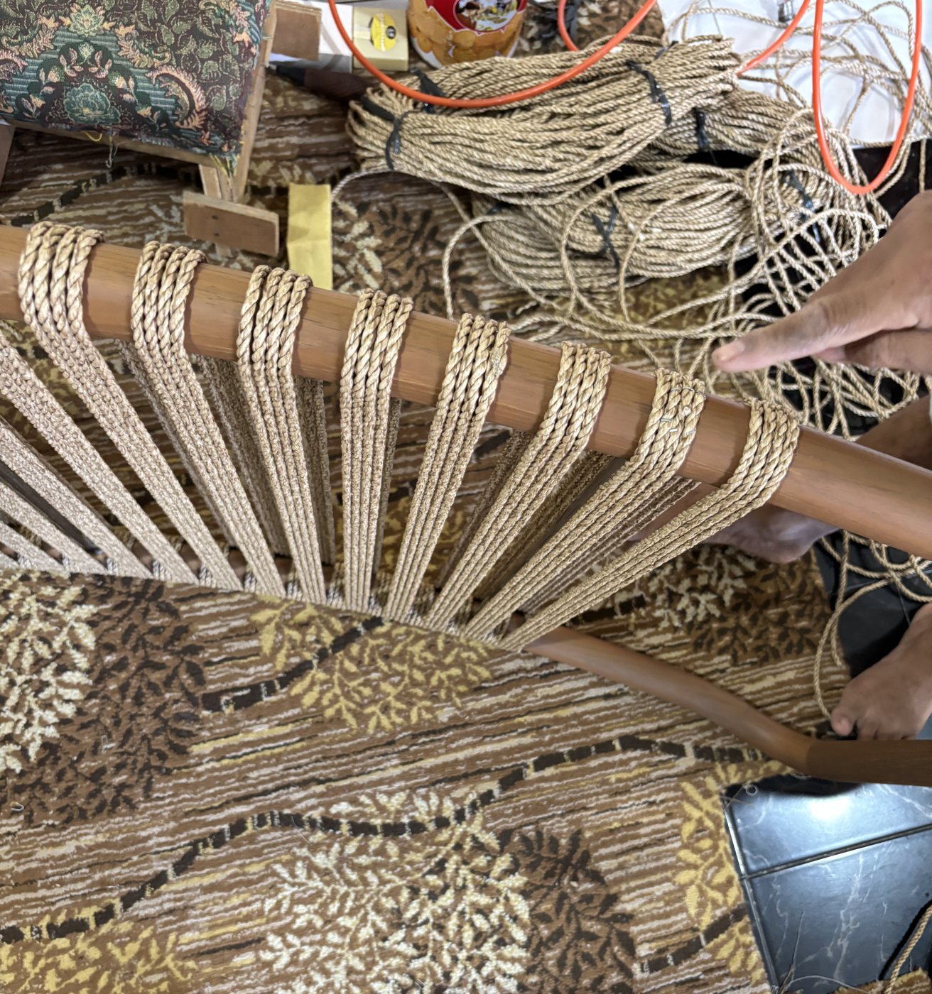 Rope weaving in progress on a timber frame